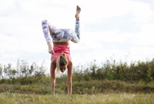 Agile young woman doing a handstand