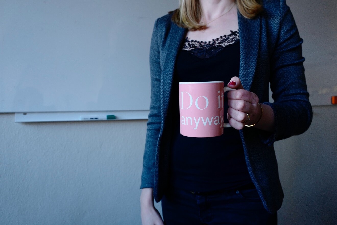Woman holding a cup that says do it anyway
