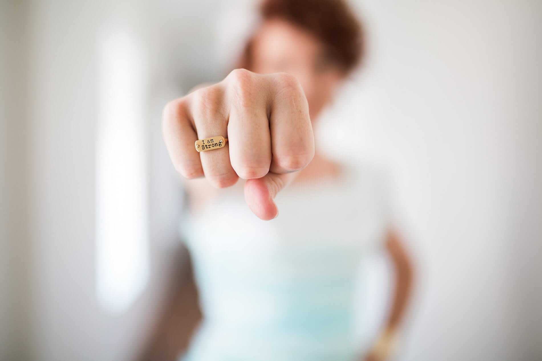 woman's fist with a ring stating I am strong