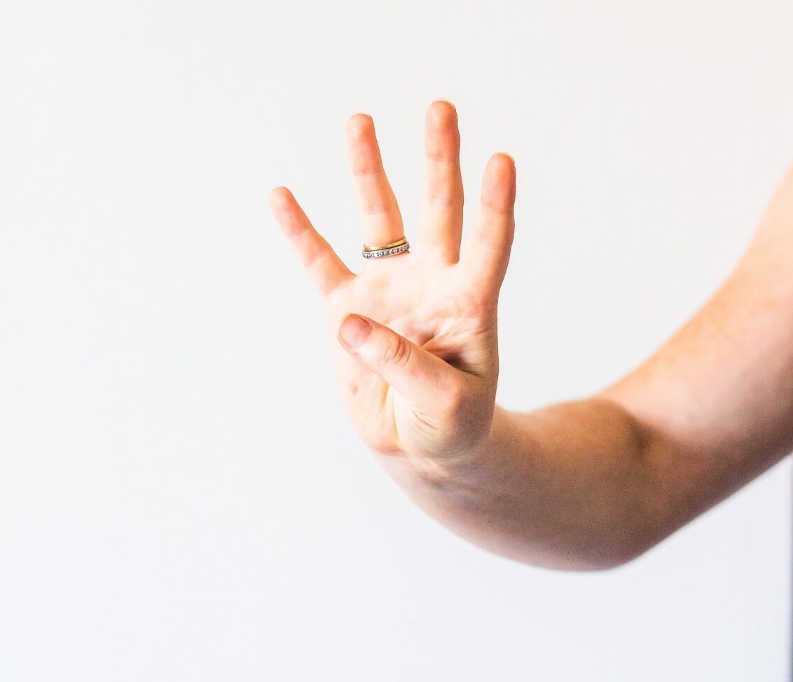 Grow your business with these four areas of commitment woman holding up hand and four fingers