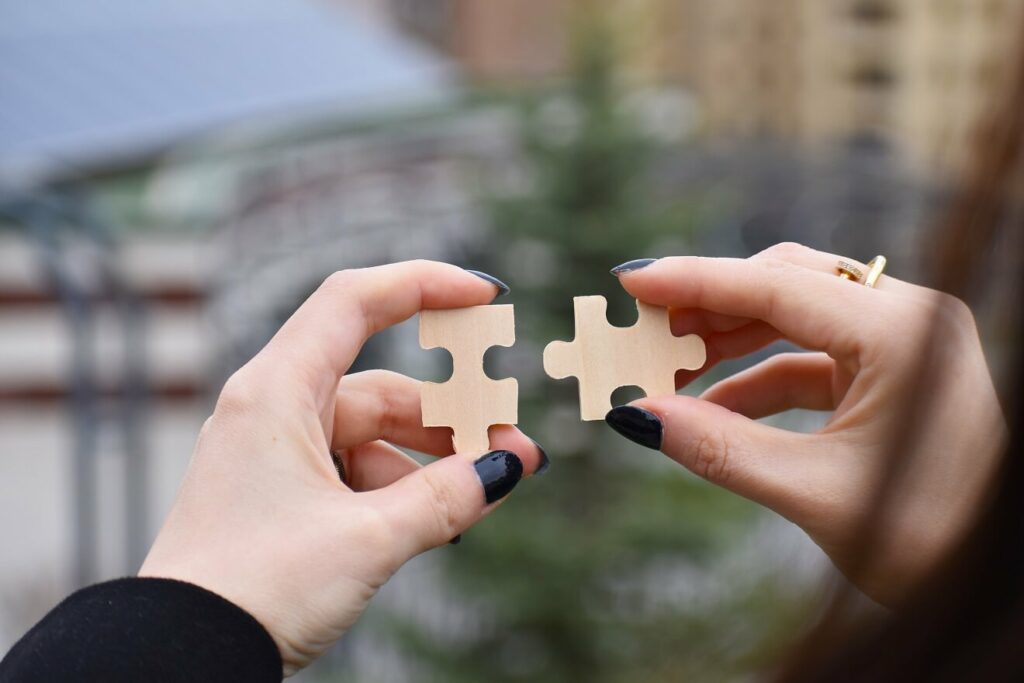 woman putting two puzzle pieces together to show how to get out of the trap of indecision in your business