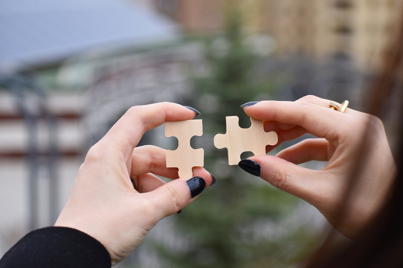 woman putting two puzzle pieces together