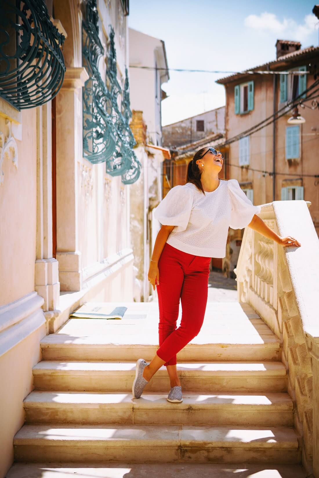 woman wearing red pants looking up to the sun