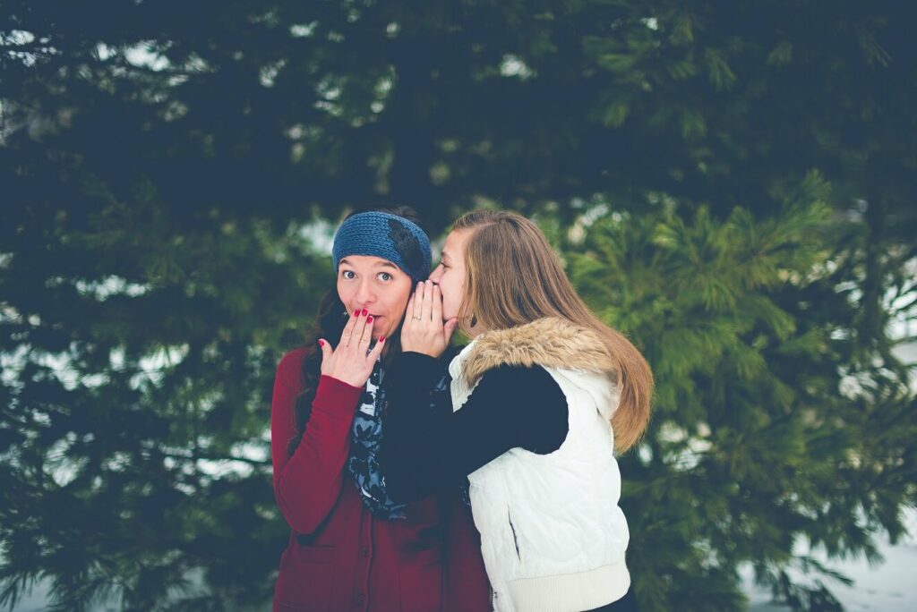 Two women telling a secret for blog post how to know God's plan for your next steps as an entrepreneur