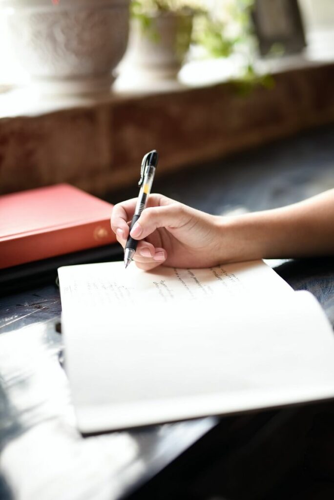 Image of a woman writing in a journal showing that doing an internal audit and journaling it is needed to learn how to be an intentional entrepreneur